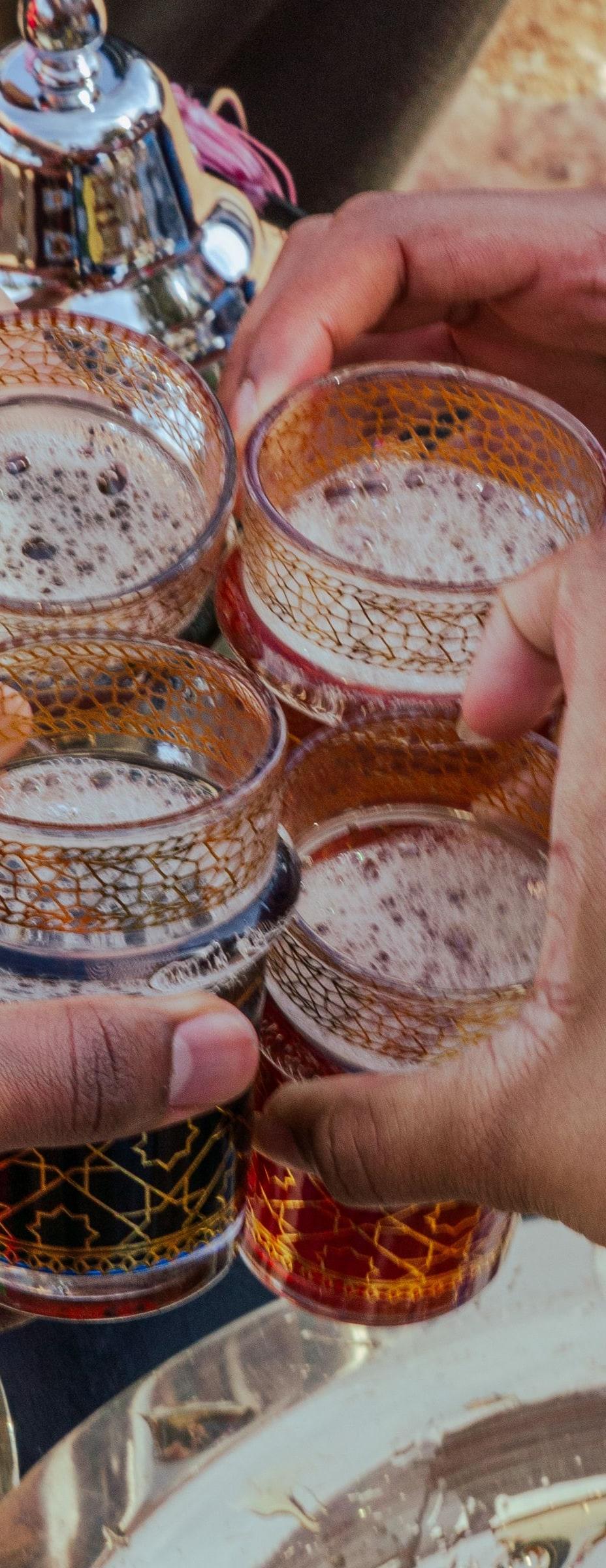 People raising Moroccan tea glasses together in Marrakesh